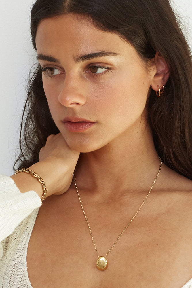model wearing gold necklace and bracelet