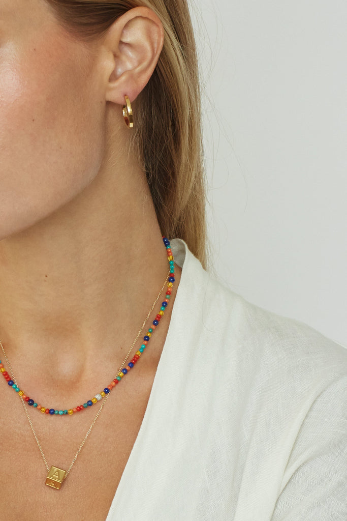 Model cropped view of 14K Diamond Multi-Bead Necklace, letter block Necklace & small simple gold hoops  bagatiba