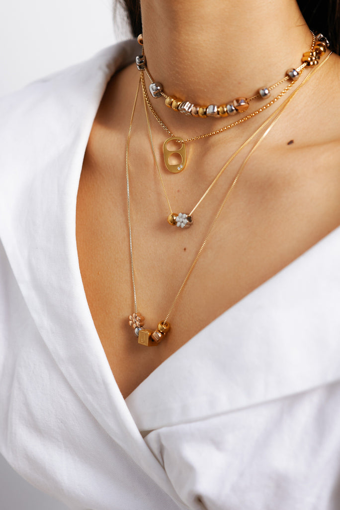 Close view crop on model of assorted chains with Gold Bead Set Bagatiba