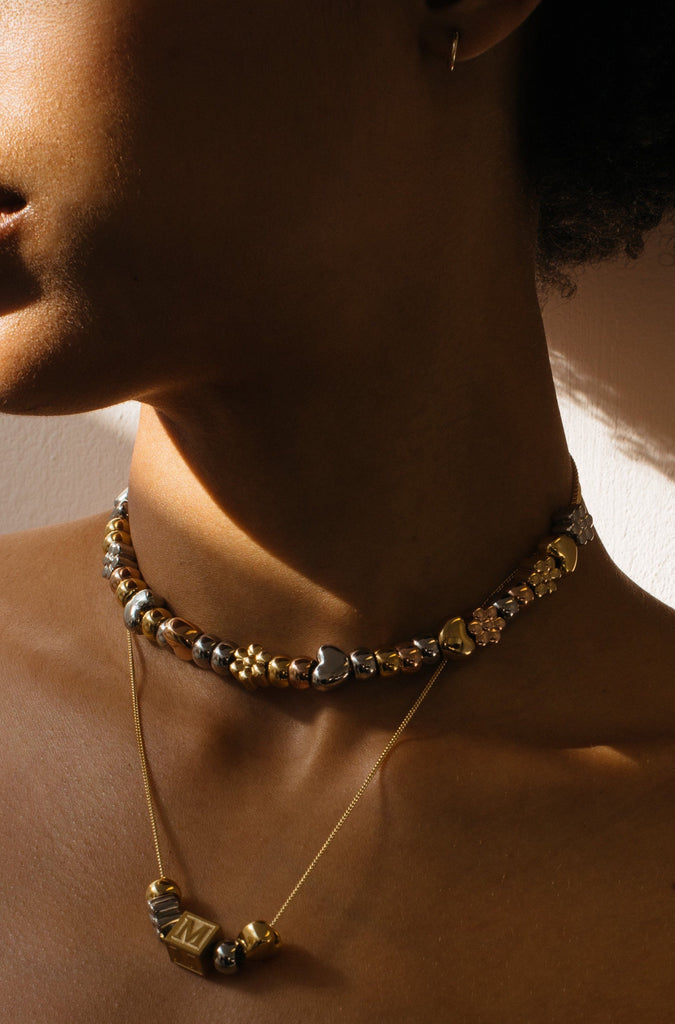 Model profile view wearing the Gold Bead Set on "build it" necklaces  Bagatiba