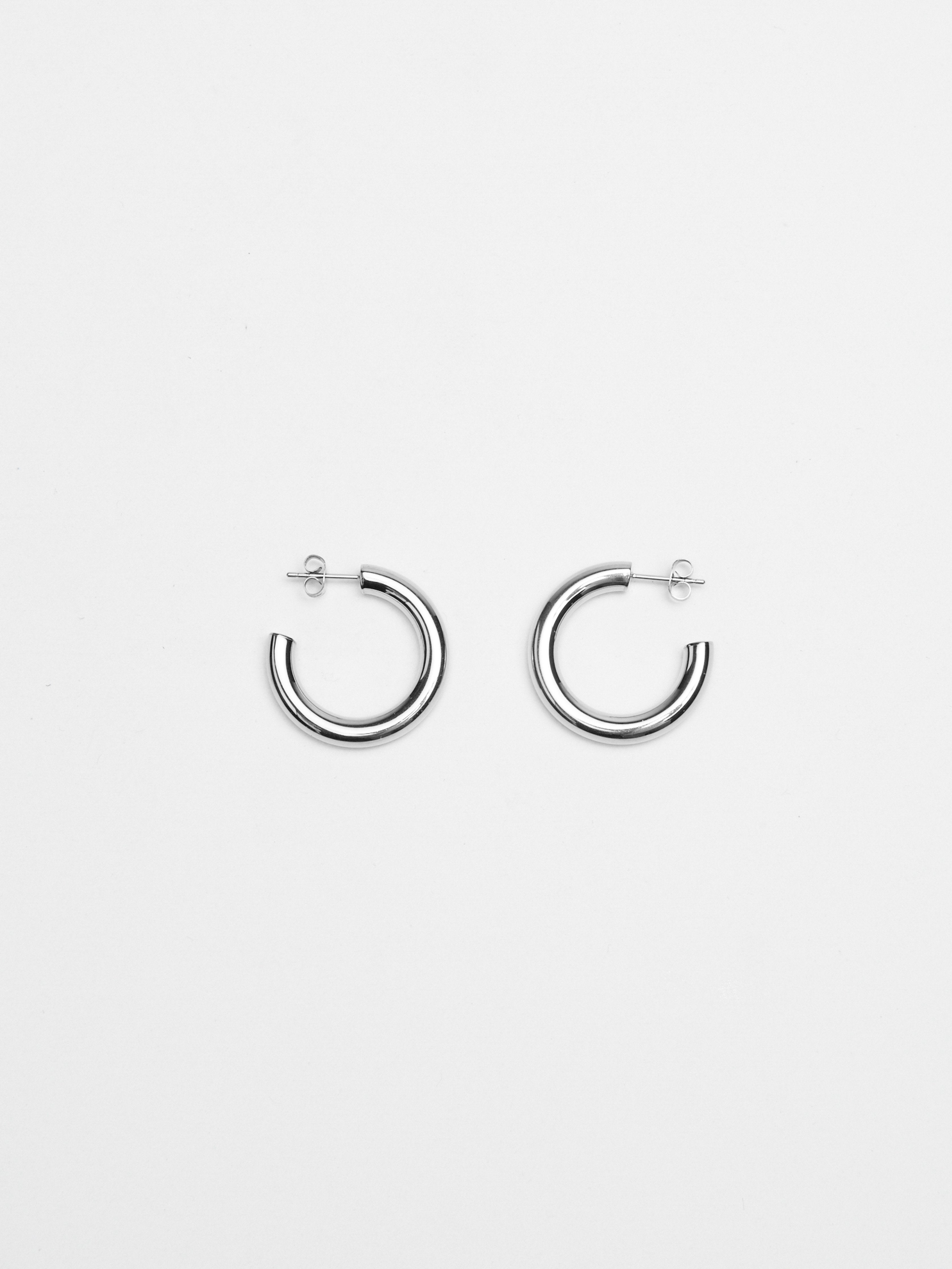 Flat lay of Mini Silver Hollow Hoops Earrings Bagatiba 