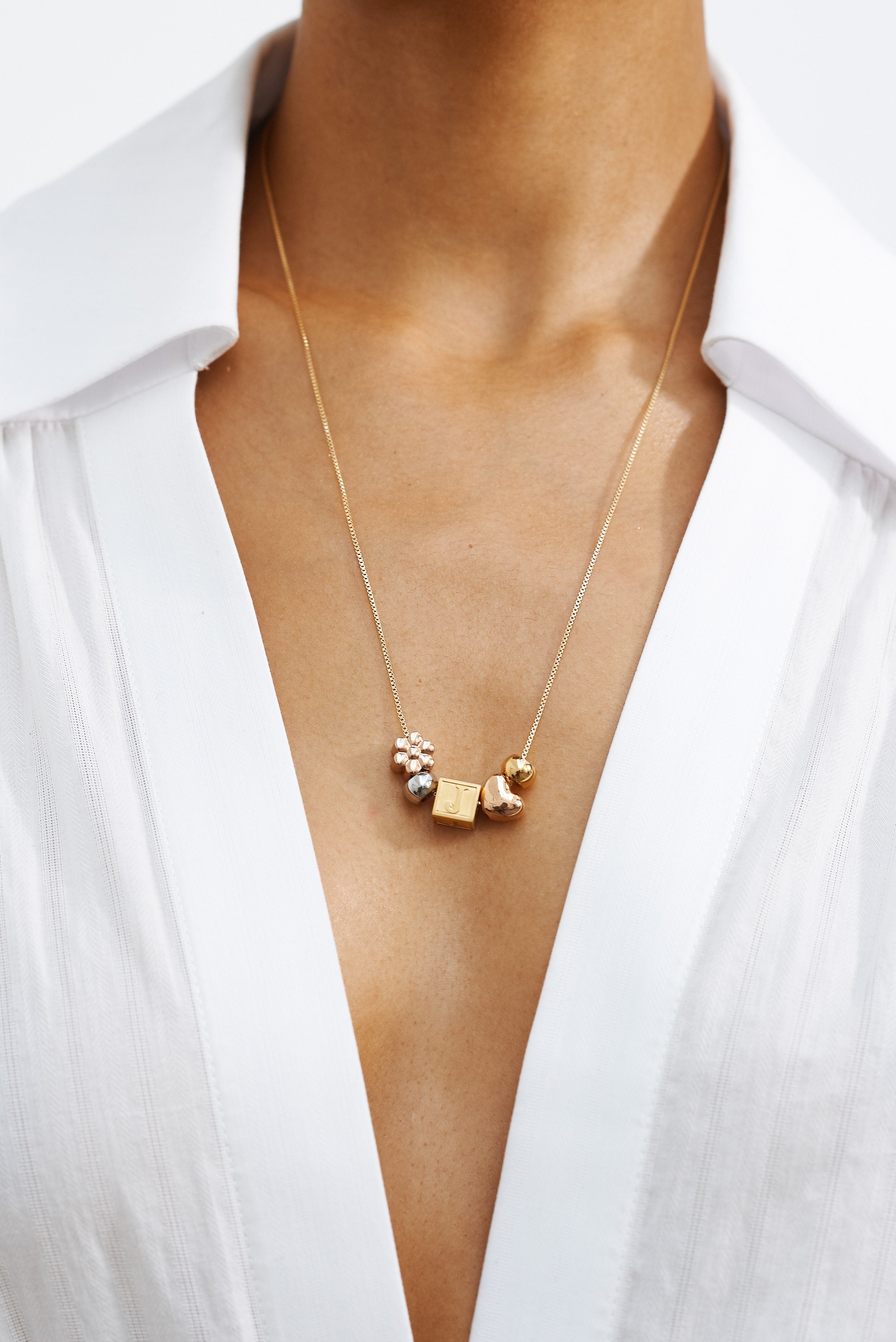 Close view of model wearing Multi-Color Bead Set paired with a letter block on chain by  Bagatiba 