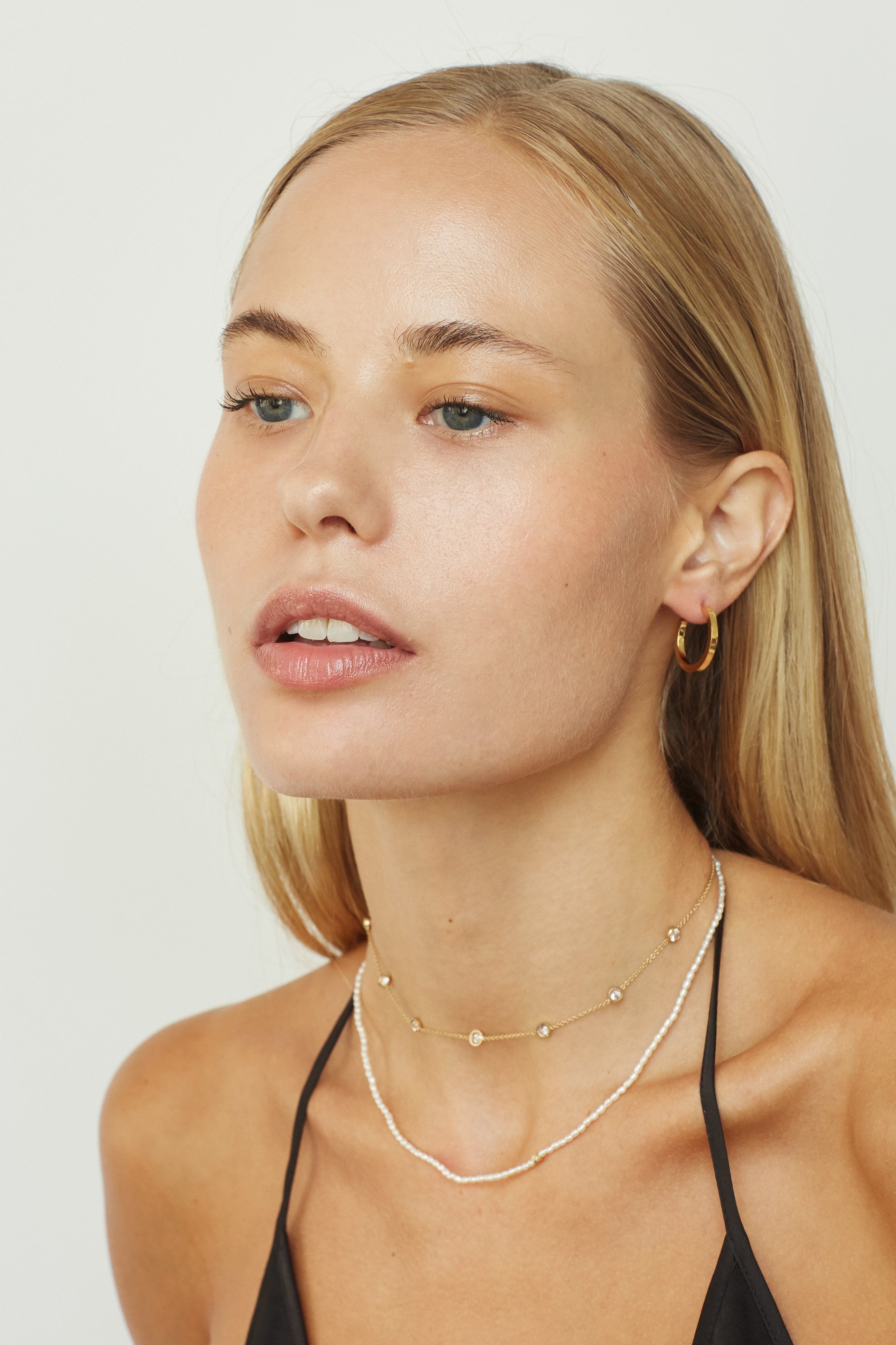 Model wearing the Princess Choker, 14k diamond pearl necklace and small simple hoops by Bagatiba 