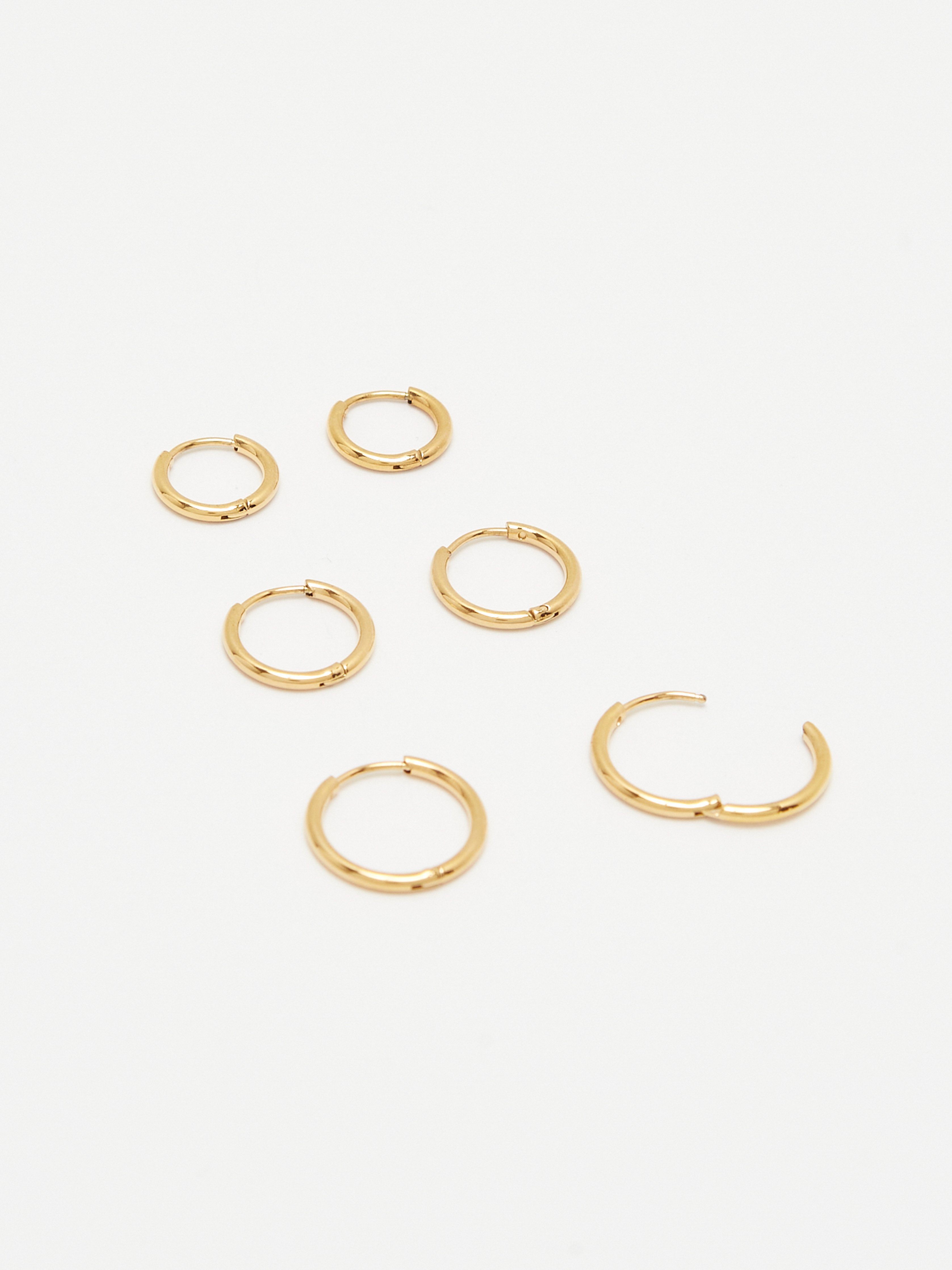Cropped flat lay view Set of Gold Eco Huggies Earrings Bagatiba 