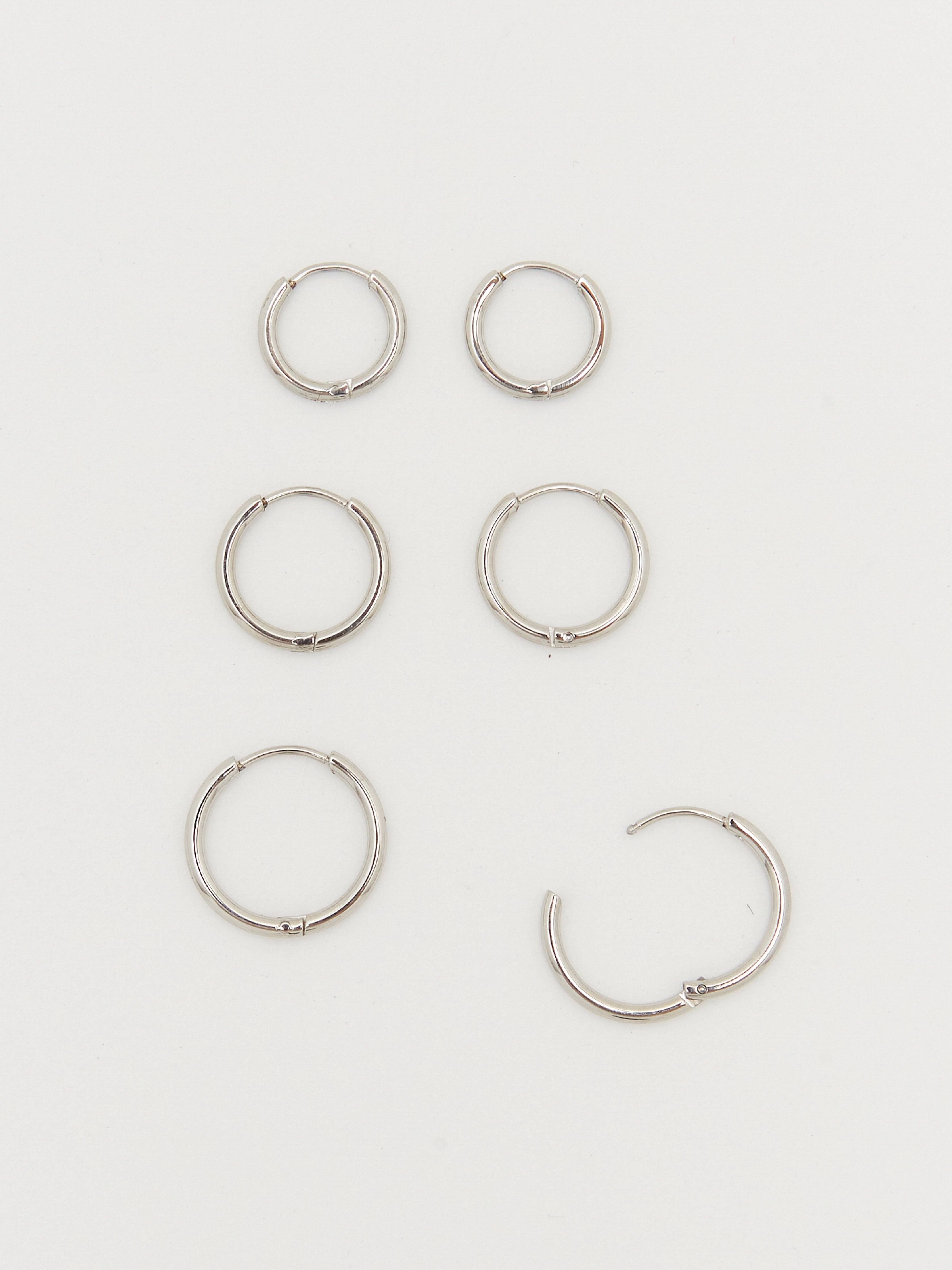 Cropped overhead flat lay view of Set of Silver Eco Huggie Hoops Earrings Bagatiba 