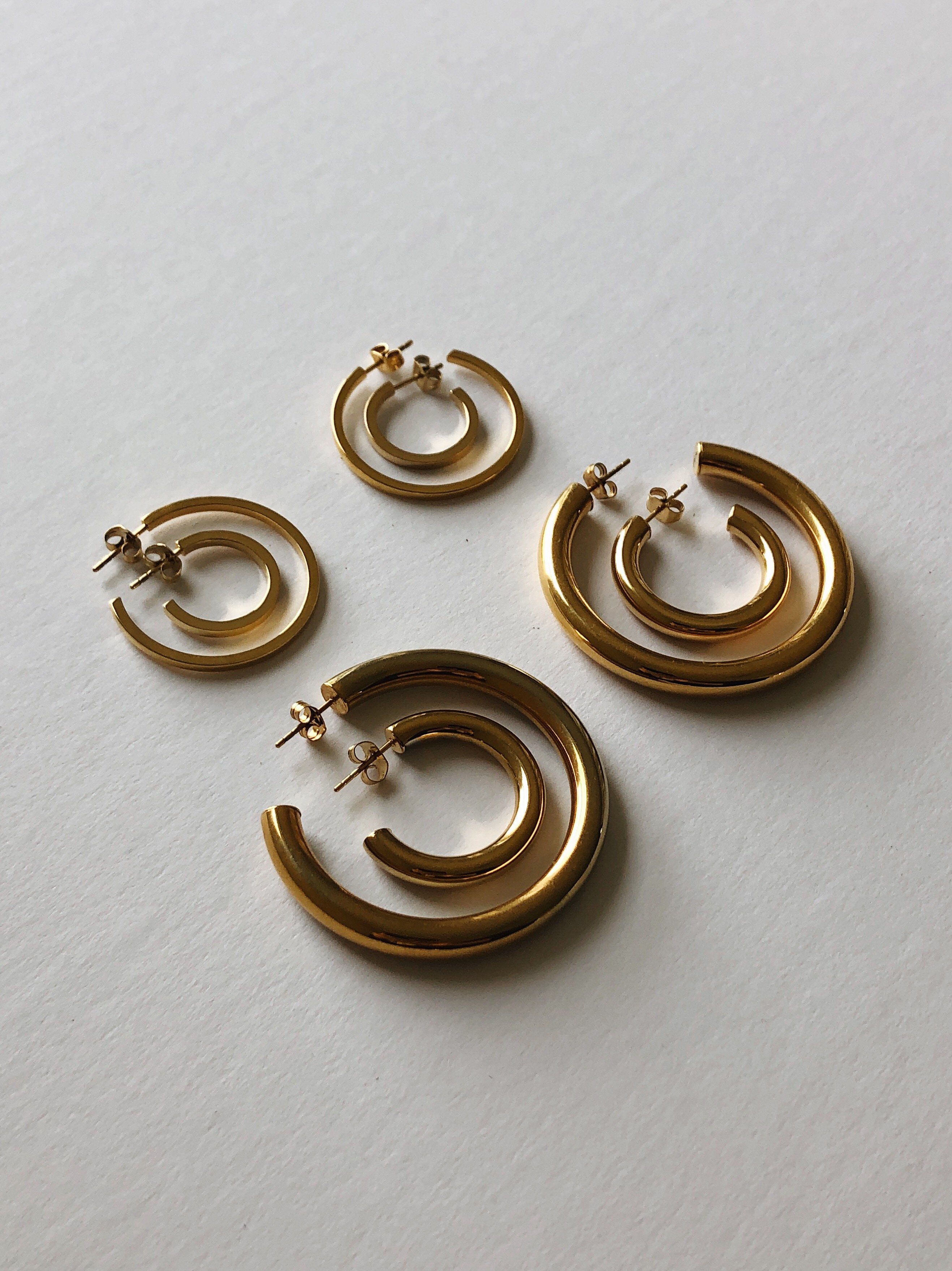 Flat lay of Simple Gold Hoops, Small simple gold hoops, Mini Gold Hollow Hoops and Gold Hollow Hoops  Earrings by Bagatiba 