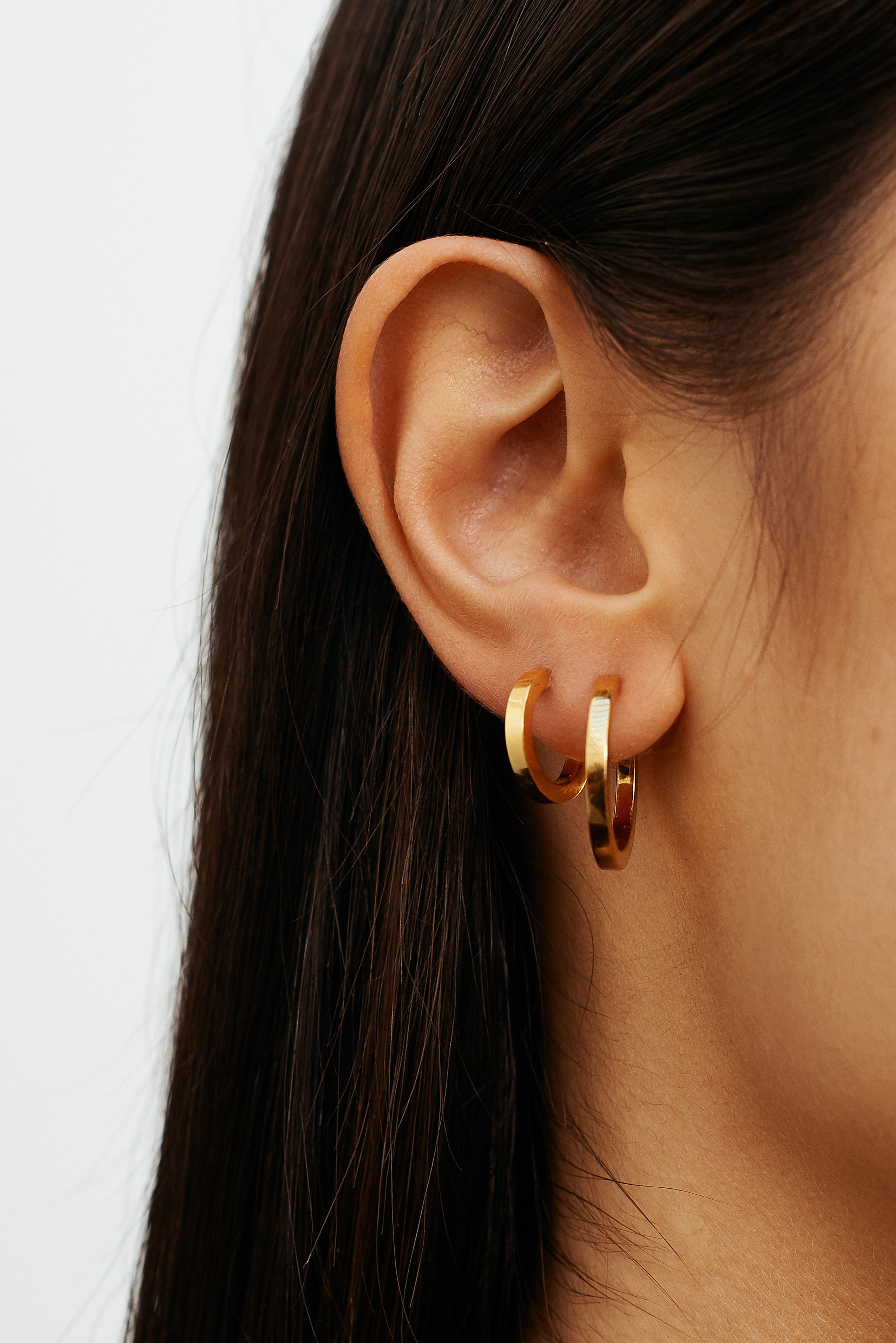 Close view on model's ear of Small Simple Gold Hoops Earrings Bagatiba 